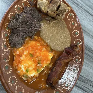 Huevos rancheros , barbacoa , beans , bacon, and Chicharron