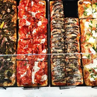 a variety of pizzas on display