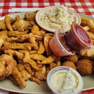 a plate of fried chicken, fries, coleslaw and coleslaw