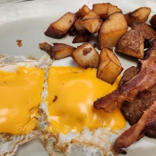 a plate of eggs, bacon and potatoes