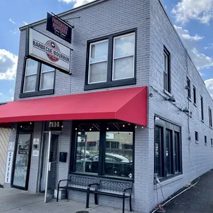 a brick building with a red awning