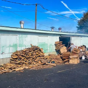 a large pile of wood in front of a building
