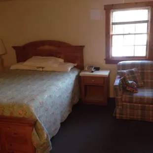 The bed and love seat in the room.