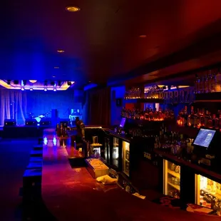 a dimly lit bar with a laptop on the counter