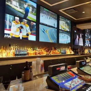 a man at a bar with multiple televisions
