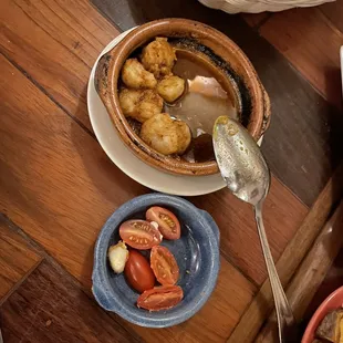 a bowl of soup with shrimp and tomatoes