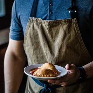 a man holding a plate of pastries