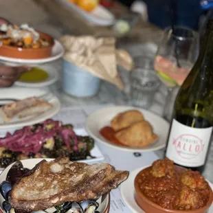 Clockwise - meatballs, mussels, Brussels sprouts, sweet potatoes (back left), empanadas, bottle of wine