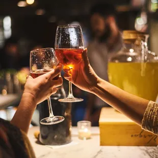 two people clinking glasses of wine