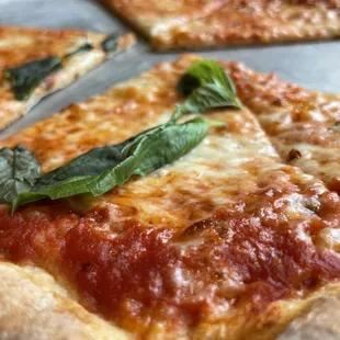 a slice of pizza with basil on top