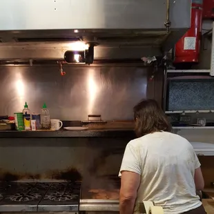 a woman preparing food in a commercial kitchen