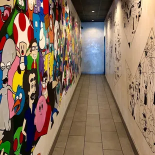 a long corridor with cartoon characters on the walls