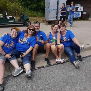 a group of people sitting on a curb