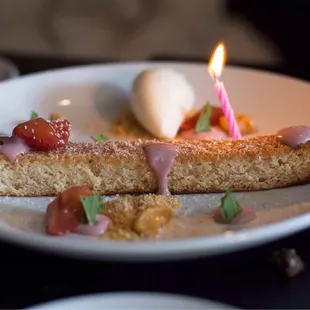 a plate of food with a candle on it