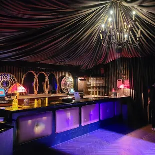 a bar with a chandelier in the background