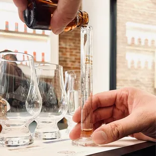 a person pouring a glass of bourbon
