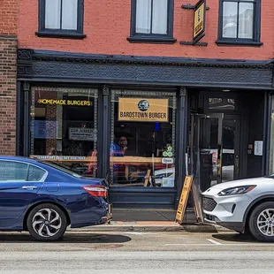 two cars parked in front of a restaurant