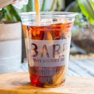 a person pouring a drink into a cup