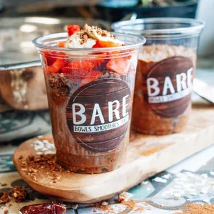 two cups of dessert on a cutting board