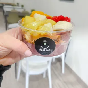 a person holding a bowl of fruit