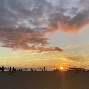 people on the beach at sunset