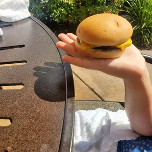 a person holding a hamburger