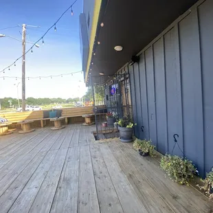 a wooden deck with benches and tables
