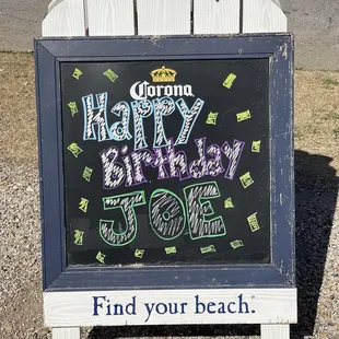 a happy birthday sign in front of a beach chair
