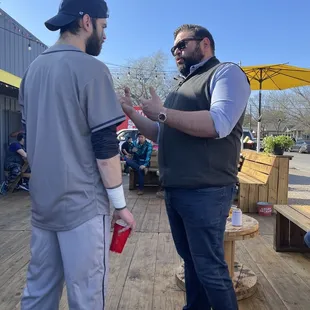 two men having a conversation on a deck