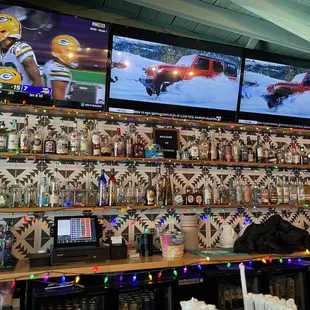 a wall of televisions and beer