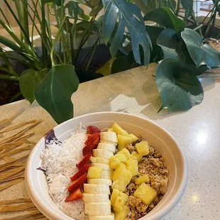 a bowl of fruit, rice, and strawberries