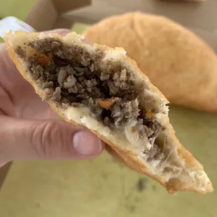 a hand holding a half eaten sandwich