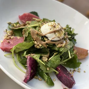 a plate of salad with meat and greens