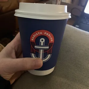 a hand holding a coffee cup