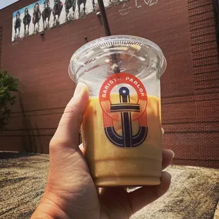 a hand holding a cup of iced coffee