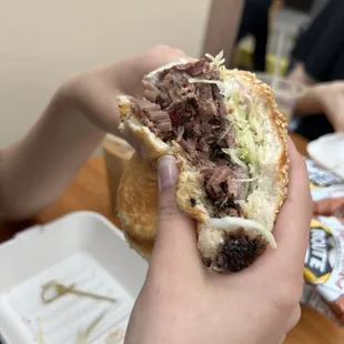 a person holding a half eaten sandwich