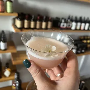 a hand holding a cocktail in a glass