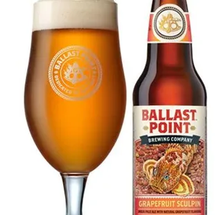 a bottle of ballast point beer next to a glass of beer