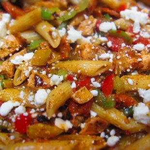 a pasta dish with chicken, peppers, and feta cheese