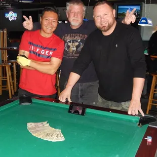 three men playing a game of pool