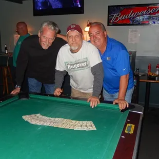 three men playing a game of pool