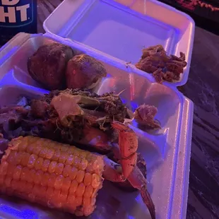 a tray of food with corn on the cob