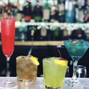 a variety of cocktails on a bar