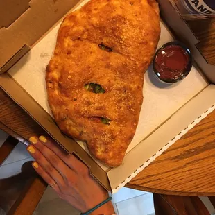 Calzone next to my hand to show you how huge it is