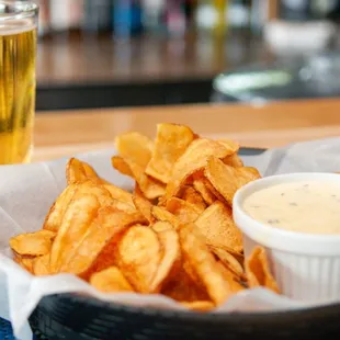 a basket of chips and a glass of beer