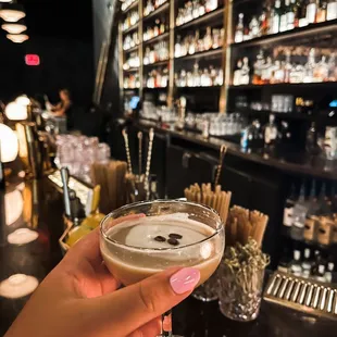 a hand holding a martini glass