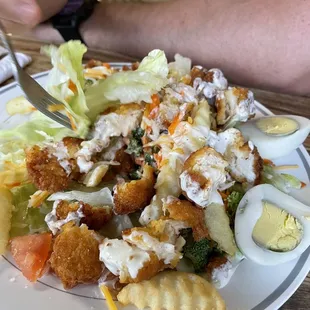 Crispy chicken salad comes with fries and hard boiled eggs. Filling and fresh.