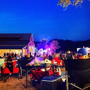 a crowd of people sitting in lawn chairs