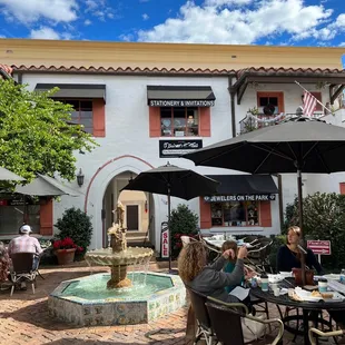 a courtyard with tables and umbrellas