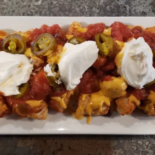 a plate of nachos with sour cream